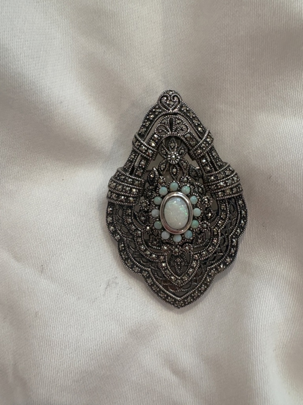 Ornate Silver-Tone Filigree Brooch with Opalescent Center